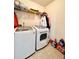 Functional laundry room featuring a modern washer and dryer, with shelving for storage at 3981 Isaac Ct, Lilburn, GA 30047