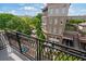 View from the balcony overlooking the courtyard and neighborhood with green trees and a brick building at 58 Canton St # 404, Alpharetta, GA 30009