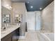 Elegant bathroom featuring double sink vanity with marble countertops, and a glass shower and tub enclosure at 58 Canton St # 404, Alpharetta, GA 30009