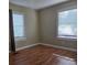 Bedroom has two windows with white frames, blinds, neutral walls and hardwood floors at 6136 Holiday Blvd, Forest Park, GA 30297