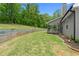 The expansive backyard features a lush lawn, wood retaining wall, and access to the house's covered porch at 114 Brookstone Dr, Carrollton, GA 30116
