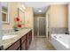 Bright bathroom features granite counters, double sinks, soaking tub and shower with glass doors at 114 Brookstone Dr, Carrollton, GA 30116