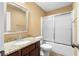 A bathroom with granite countertops, framed mirror, and a shower/tub combo with sliding glass doors at 114 Brookstone Dr, Carrollton, GA 30116