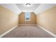 Empty bedroom with carpet, window with natural light, and beige walls, offering a blank canvas at 114 Brookstone Dr, Carrollton, GA 30116