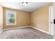 An empty bedroom with a window and neutral carpet and paint at 114 Brookstone Dr, Carrollton, GA 30116