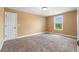 A simple, carpeted room with a closet and window provides a blank canvas at 114 Brookstone Dr, Carrollton, GA 30116