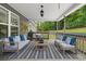 Inviting covered porch with cozy seating, rug, and view of the lush green landscape creates a relaxing outdoor retreat at 114 Brookstone Dr, Carrollton, GA 30116