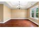 Elegant dining room featuring hardwood floors, tray ceilings, a chandelier, and natural light at 114 Brookstone Dr, Carrollton, GA 30116
