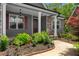 Inviting front porch with stone accents, gray siding, red shutters, and well-kept landscaping at 114 Brookstone Dr, Carrollton, GA 30116