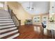 Open-concept living room with hardwood floors, a stone fireplace, staircase, and access to the back patio at 114 Brookstone Dr, Carrollton, GA 30116