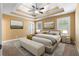 Primary bedroom with tray ceilings, carpet, natural light, and a king size bed for a relaxing retreat at 114 Brookstone Dr, Carrollton, GA 30116
