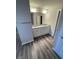 Modern bathroom featuring a double sink vanity with granite countertop and wood-look flooring at 115 Deer Xing, Temple, GA 30179