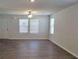 Spacious living room with hardwood floors, abundant natural light, and modern lighting fixtures creating a warm atmosphere at 115 Deer Xing, Temple, GA 30179