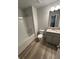 Well-lit bathroom features a shower-tub combo, modern fixtures, and wood-look flooring at 123 Deer Xing, Temple, GA 30179