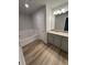 Bathroom featuring granite countertops, a tub, and light wood flooring at 123 Deer Xing, Temple, GA 30179
