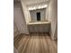 Bathroom featuring double sinks, granite countertops, wood flooring, and a large mirror at 123 Deer Xing, Temple, GA 30179