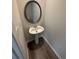 Cozy powder room features a pedestal sink, modern fixtures, and stylish wood-look flooring at 528 Earnest Ln, Temple, GA 30179
