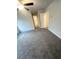 A cozy bedroom showcases neutral carpeting, a ceiling fan, and a door leading to the hallway at 100 Deer Xing, Temple, GA 30179