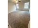 A bright bedroom with neutral carpeting, two windows, and a ceiling fan at 131 Deer Xing, Temple, GA 30179