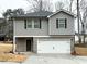 Two-story home featuring gray siding, brick accents, and an attached two-car garage at 131 Deer Xing, Temple, GA 30179