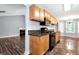 Open kitchen featuring wood cabinetry, black appliances, granite countertops, and adjacent dining area at 285 Kentshire Pl, Lawrenceville, GA 30044