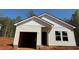 New construction home featuring light siding, an attached garage, and a classic roofline at 451 Courthouse Park Dr, Temple, GA 30179