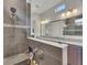 A bathroom featuring a gray-tiled shower with a built-in seat, a handheld shower head, and granite countertops at 250 Cordova St, Woodstock, GA 30189