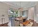 Dining area with wooden table, bench seating, modern chandelier, and sliding glass doors to the outdoor patio at 250 Cordova St, Woodstock, GA 30189