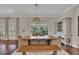 Dining area with wooden table, bench seating, modern chandelier, and sliding glass doors to the outdoor patio at 250 Cordova St, Woodstock, GA 30189