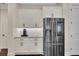 Modern kitchen with stainless steel refrigerator, white cabinets, granite countertops, and dark hardwood floors at 250 Cordova St, Woodstock, GA 30189