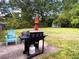 Expansive backyard features a grill, a blue chair, a green lawn and trees, perfect for outdoor activities at 4179 Westview St, Douglasville, GA 30135