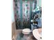 A full bath with a toilet, and sink all adjacent to a butterfly patterned shower curtain at 4179 Westview St, Douglasville, GA 30135