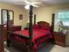 Bedroom with four-poster bed, red and black checkered bedding, and coordinating furniture at 4179 Westview St, Douglasville, GA 30135