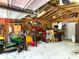 Spacious garage interior with exposed beams, workbenches, equipment and overhead storage creating an organized workspace at 4179 Westview St, Douglasville, GA 30135