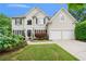Charming two-story home with a manicured front yard, black shutters, and a two car garage at 1360 Woodvine Way, Alpharetta, GA 30005