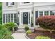 Charming entryway with decorative wreath, stone steps, manicured landscaping, and black accent shutters at 1360 Woodvine Way, Alpharetta, GA 30005