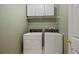 Laundry room equipped with washer, dryer, shelving, and white cabinets at 1360 Woodvine Way, Alpharetta, GA 30005