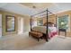 Spacious main bedroom with a four-poster bed, bench, and large windows at 1360 Woodvine Way, Alpharetta, GA 30005