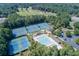 An aerial view showcasing the pool and tennis courts nestled in a lush green community at 2118 Town Manor Ct, Dacula, GA 30019