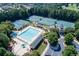 Aerial view showcases community tennis courts and large pool surrounded by trees at 2118 Town Manor Ct, Dacula, GA 30019