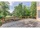 Wooden deck overlooks the expansive backyard with mature trees and landscaping, ideal for enjoying nature and outdoor living at 2118 Town Manor Ct, Dacula, GA 30019