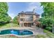 Stunning brick home featuring a backyard oasis with a pool, patio, and lush landscaping at 2118 Town Manor Ct, Dacula, GA 30019