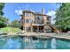 Picturesque backyard featuring an in-ground pool, brick patio, manicured lawn and home's back exterior at 2118 Town Manor Ct, Dacula, GA 30019