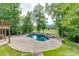 Beautiful backyard featuring a swimming pool, hot tub, lush greenery, and landscaping, perfect for outdoor recreation at 2118 Town Manor Ct, Dacula, GA 30019