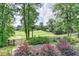 Scenic view of the backyard showcasing green lawns, trees, and attractive landscaping elements at 2118 Town Manor Ct, Dacula, GA 30019