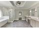 Modern bathroom with a soaking tub, glass-enclosed shower, double vanities, and stylish tile flooring at 2118 Town Manor Ct, Dacula, GA 30019