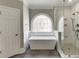 Bright bathroom featuring a soaking tub with a decorative window, a glass shower, and elegant finishes at 2118 Town Manor Ct, Dacula, GA 30019
