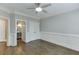 Comfortable bedroom features a ceiling fan, hardwood floors, and access to a private bathroom at 2118 Town Manor Ct, Dacula, GA 30019