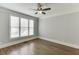 Bright bedroom featuring hardwood floors, large windows with blinds, and neutral wall paint at 2118 Town Manor Ct, Dacula, GA 30019