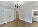 Bedroom featuring hardwood floors, wainscotting, chandelier, and ensuite bathroom at 2118 Town Manor Ct, Dacula, GA 30019